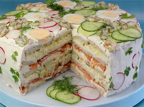 moderne Sandwichtorte im Anschnitt, verschiedene Schichten, belegt mit Gemüse und Fisch