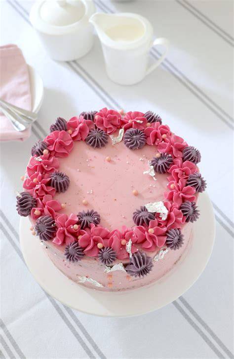 rosa Party-Torte mit Spritzbeutel und frischen Früchten