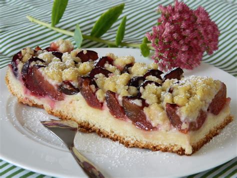 saftiger pflaumenkuchen mit streuseln auf kuchenplatte