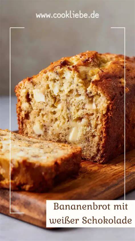 saftiges Bananenbrot aufgeschnitten auf einem Holzbrett neben weißer Schokolade