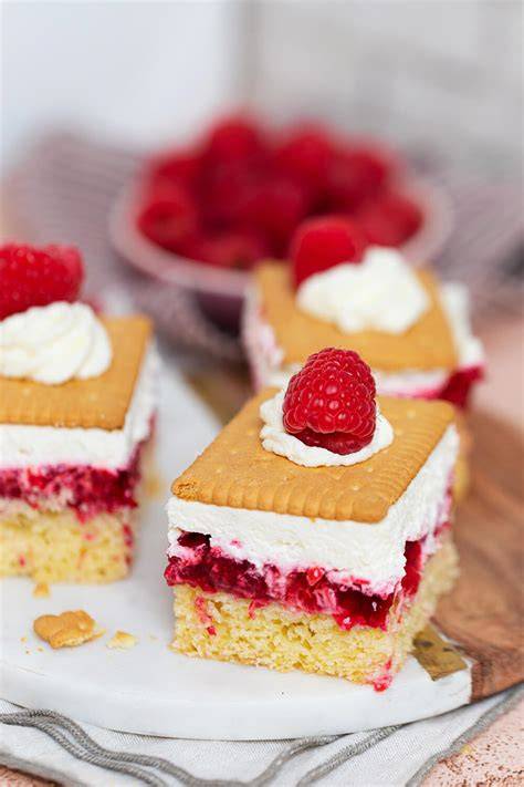 schichten der charlotten-masse mit biskuitwürfeln und himbeeren