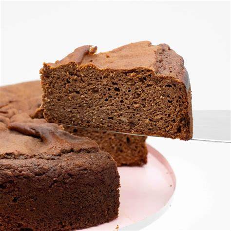 schoko quark kuchen angerichtet auf tisch mit kakaopulver und schokoladenstückchen