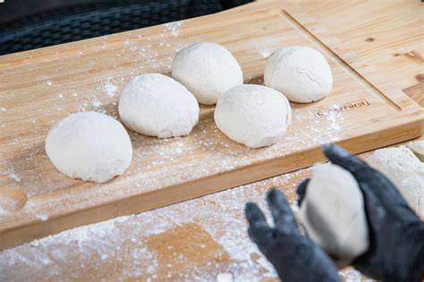 schrittbilder: teigkugeln in pinienkernen wälzen und flachdrücken