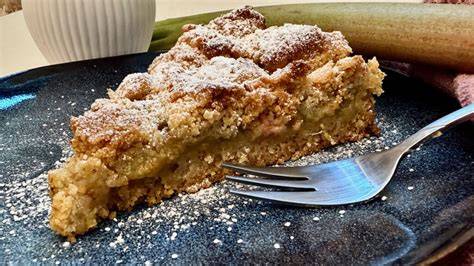 servierter Rhabarber Nuss Streuselkuchen auf Holztisch im Garten