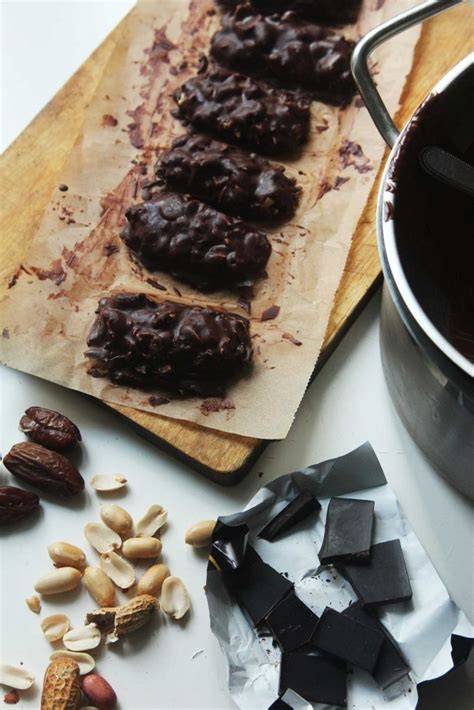 snacks mit dattel, schokolade und erdnuss angerichtet neben einer Tasse Kaffee