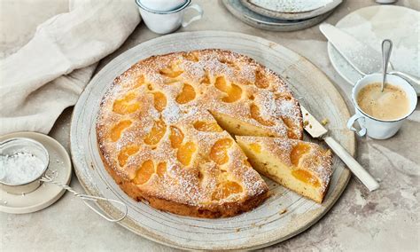 stimmungsfoto: winterliche kaffeetafel mit mandarinenkuchen und puderzucker