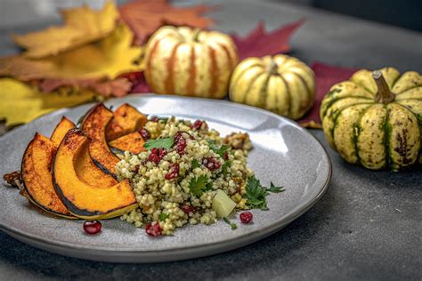 teller mit kürbis-käsekuchen, umgeben von kürbissen und herbstlaub
