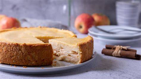 verschiedene Apfelkuchen-Varianten, angeschnitten und angerichtet auf einem Holztisch