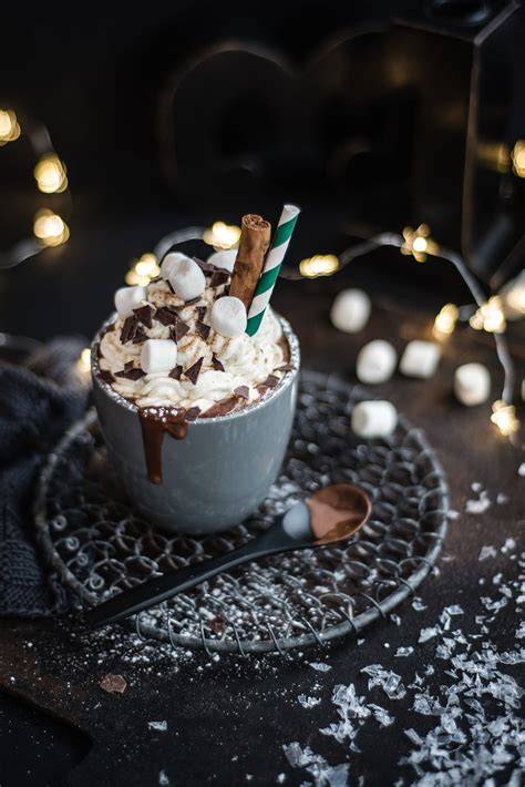 verschiedene Toppings für heiße Schokolade: Marshmallows, Sahne, Kakaopulver