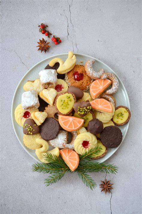 verschiedene zuckerfreie Weihnachtskekse auf bunten Tellern