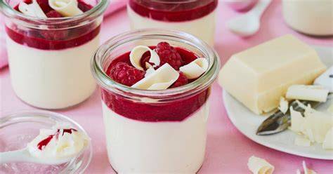 weiße Schokoladencreme im Glas mit Himbeeren
