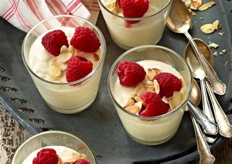 weiße Schokoladenmousse im Glas mit Himbeeren