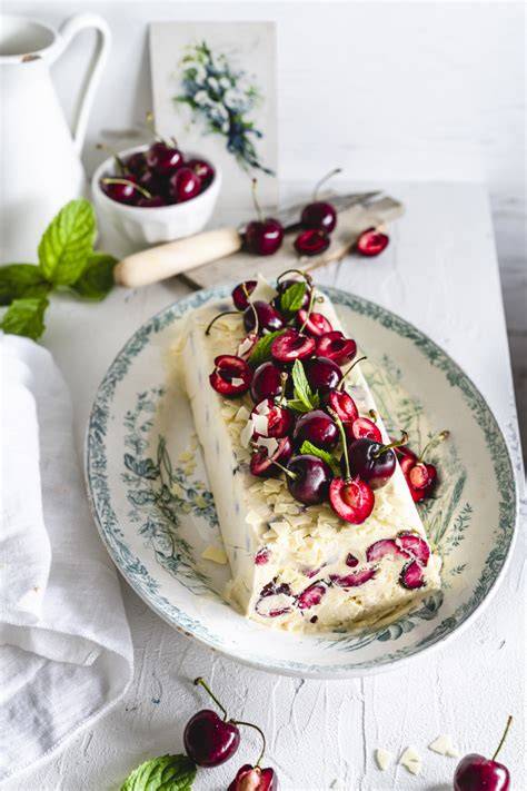 weißes Schokolade-Parfait mit frischen Kirschen dekoriert